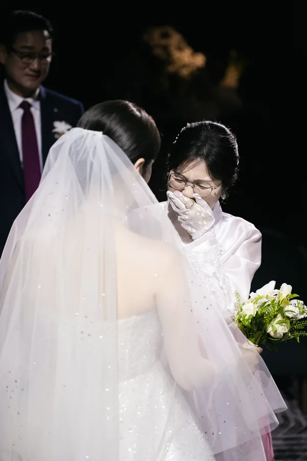 한복 입은 어머니가 눈물 훔치며 신부를 바라보는 예식 중 순간