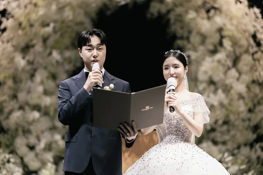 마이크 들고 성혼 서약서를 읽는 신랑신부