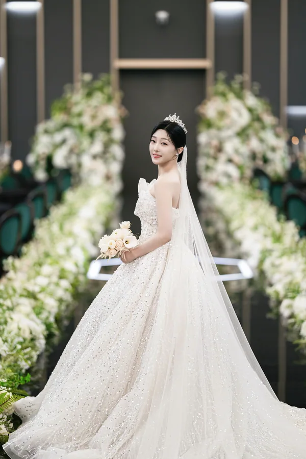 웨딩드레스 트레인을 늘어뜨리고 어깨너머로 돌아보는 신부 뒷모습 전신컷